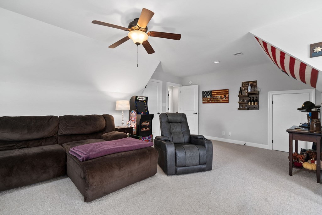 a living room with two couches and a chair and a ceiling fan