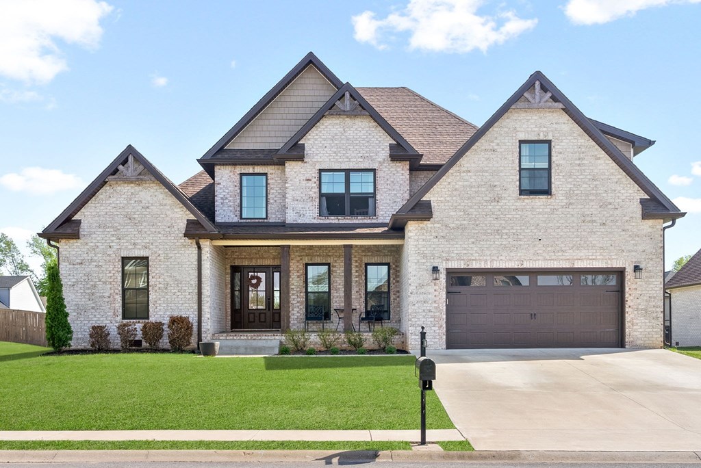 a large brick house with a driveway and a garage door