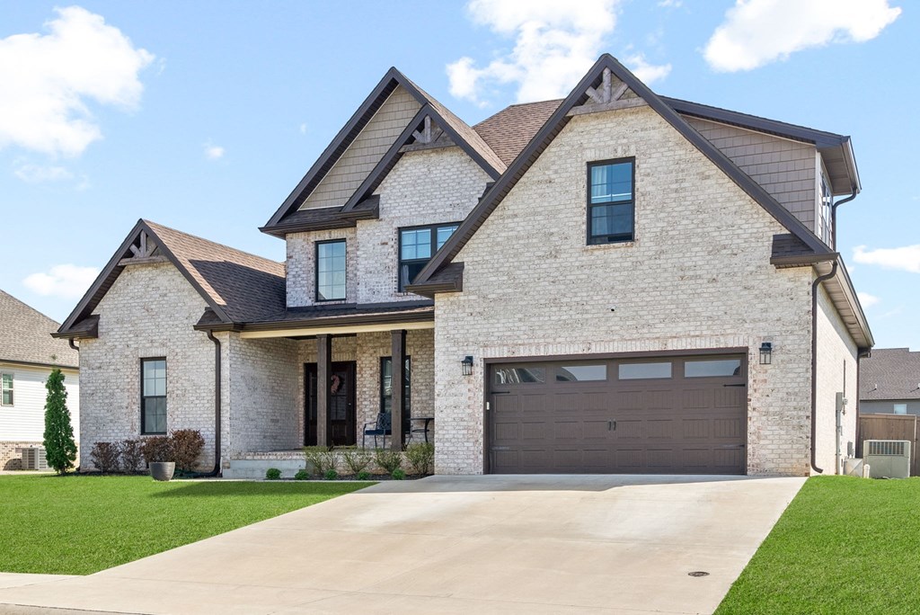 a large brick house with a driveway and a garage door