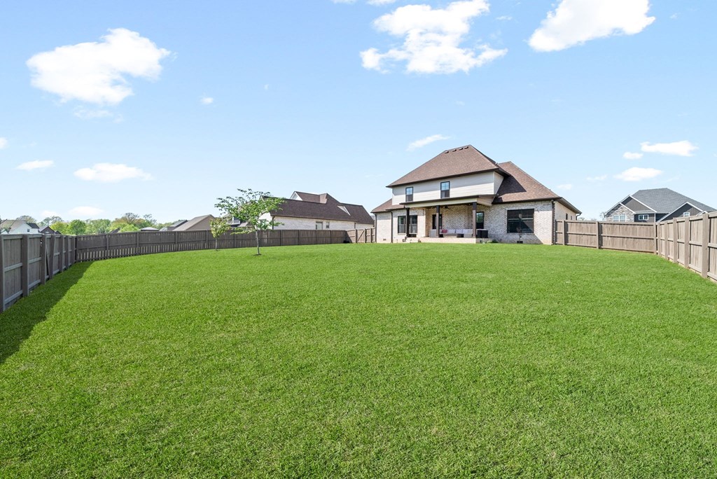 a backyard with a fence and a house