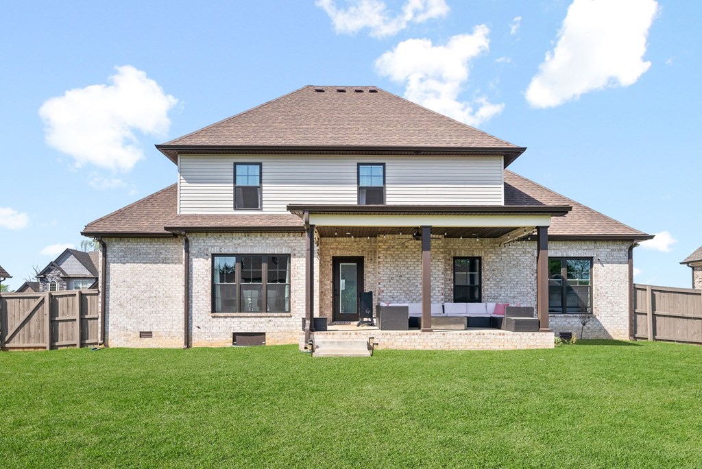 the back of a house with a lawn and a patio