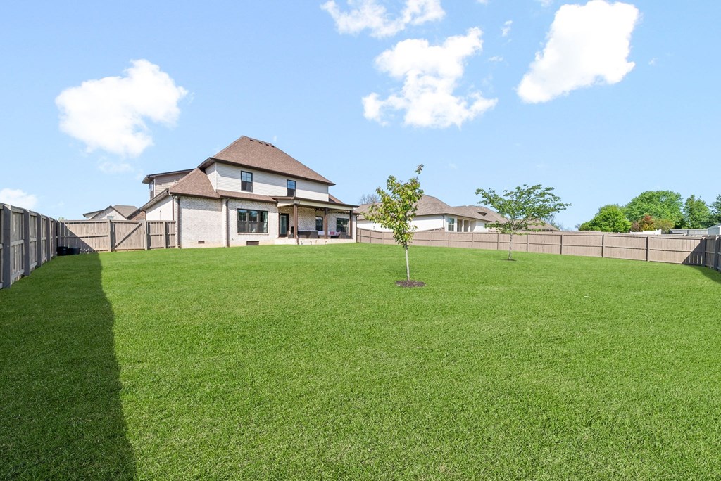 a large yard with a house in the background