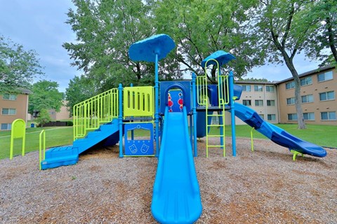 a playground with a blue and yellow swing set