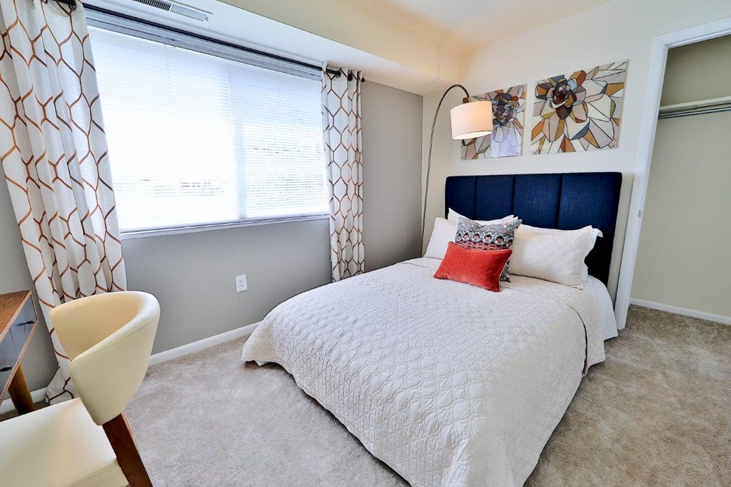 a bedroom with a bed and a large window