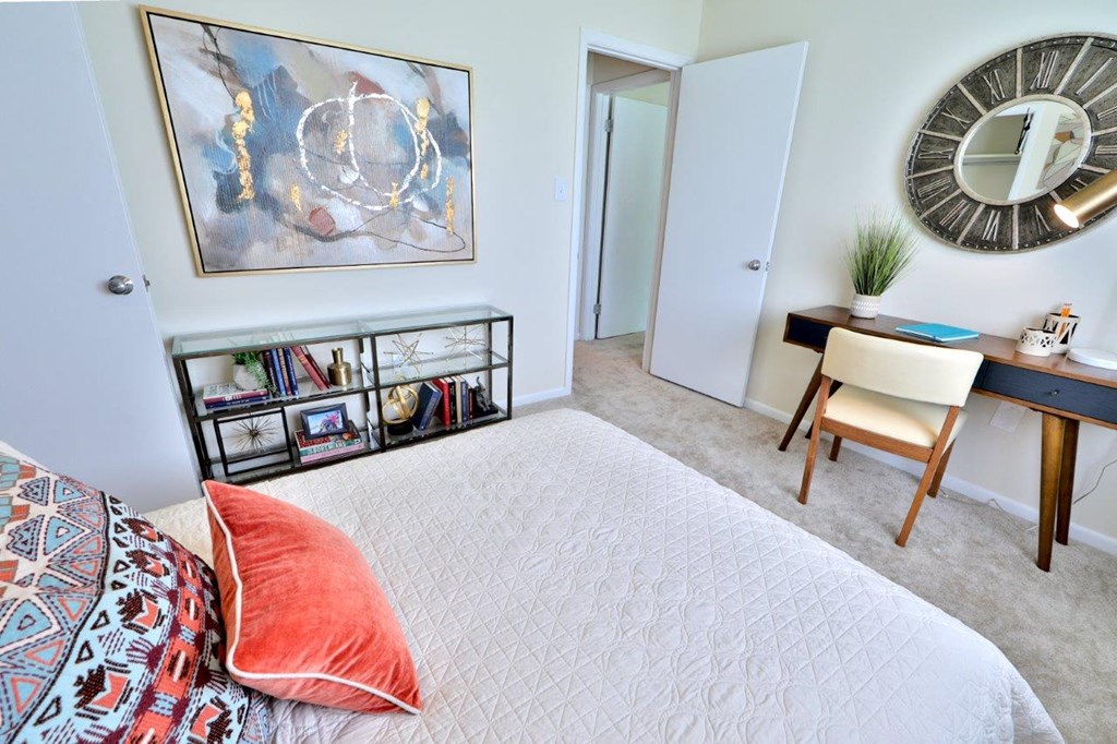 a bedroom with a bed and a desk with a mirror