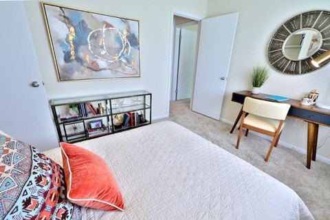 a bedroom with a bed and a desk with a mirror