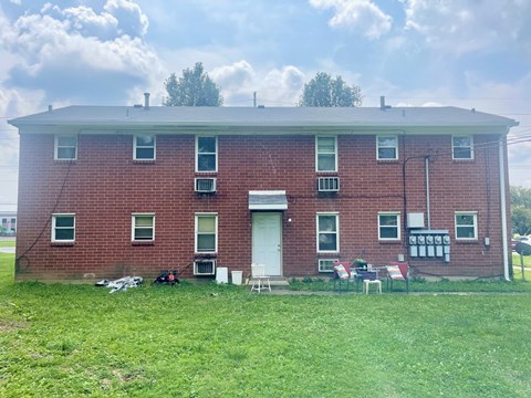 an old brick building with chairs in front of it