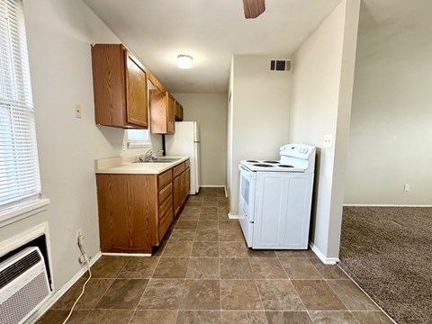 A kitchen with a white fridge and a white washing machine.