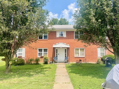 a brick house with a sidewalk in front of it
