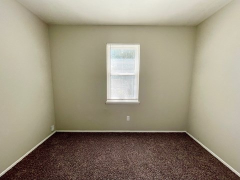 an empty room with carpet and a window