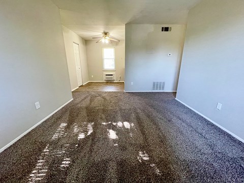 an empty living room with white walls and a gravel floor