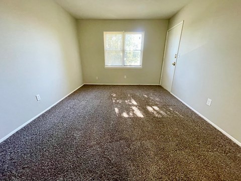 a empty room with carpet and a window