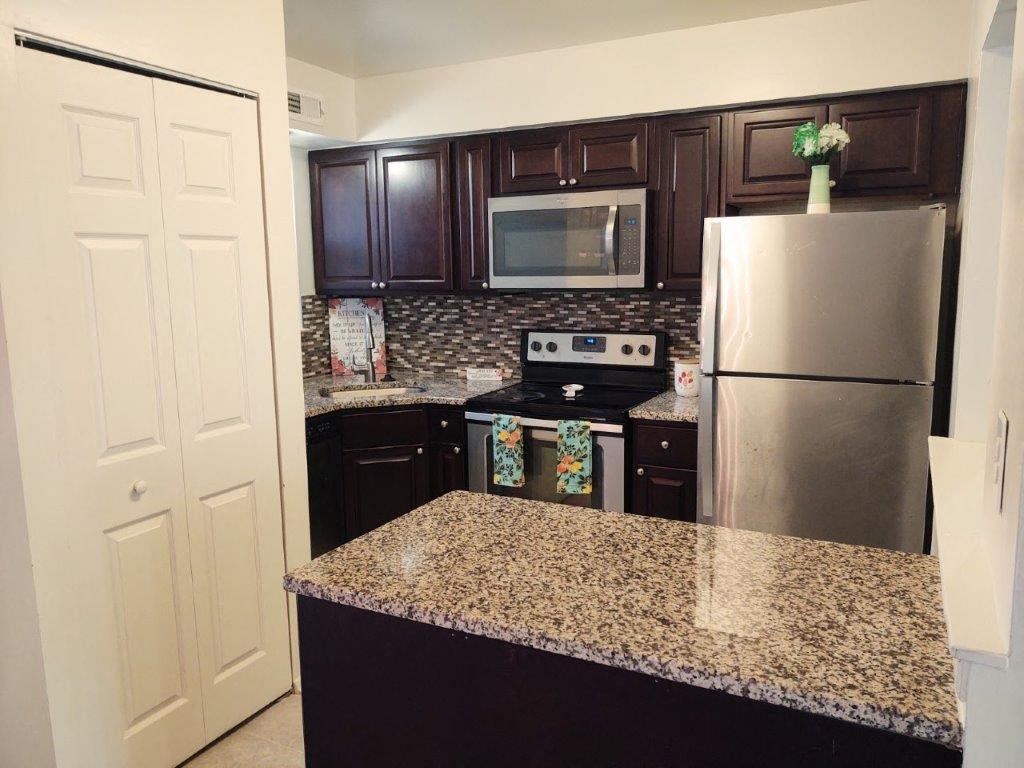 a kitchen with granite counter top and stainless steel appliances