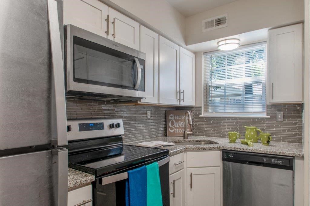 a kitchen with stainless steel appliances and white cabinets