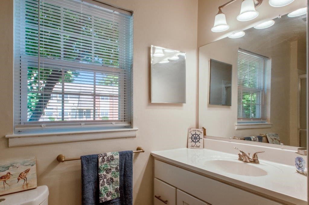 a bathroom with a sink and a mirror and a window