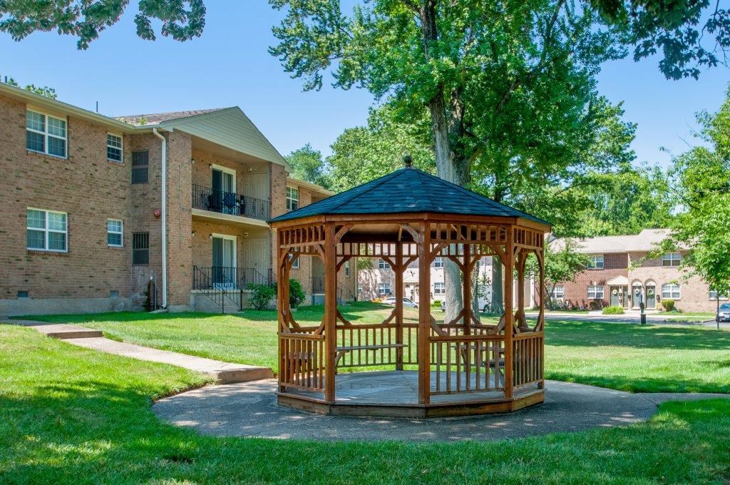 a gazebo in the middle of a yard in front of a building