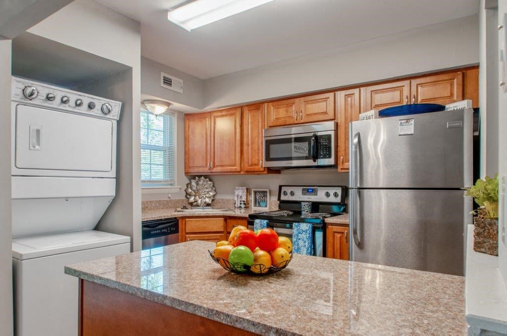 a kitchen with stainless steel appliances and a bowl of fruit