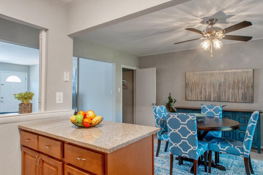 a kitchen with a island and a dining room with a table and chairs