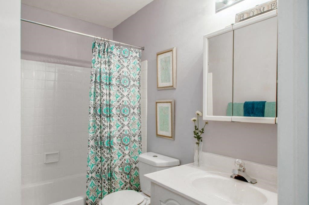 a bathroom with a shower curtain and a sink and a toilet