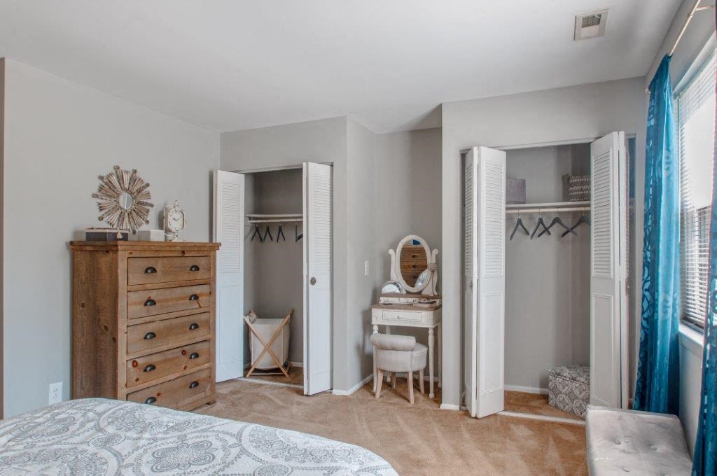 a bedroom with a closet and a dresser with a mirror