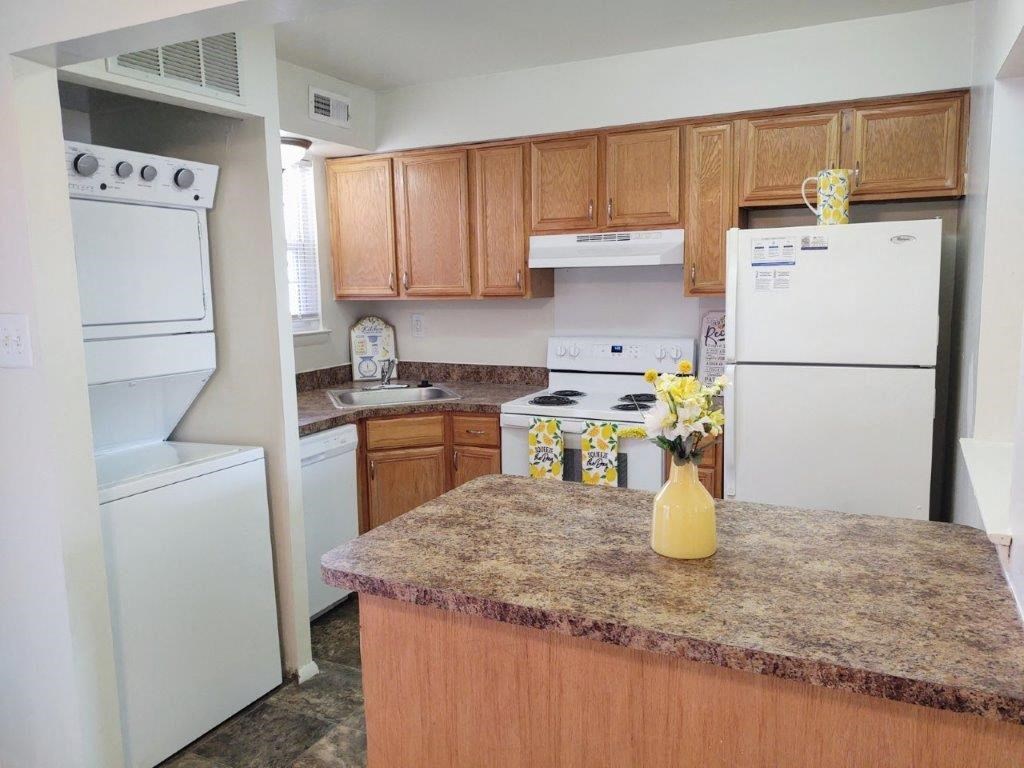 a kitchen with white appliances and a granite counter top