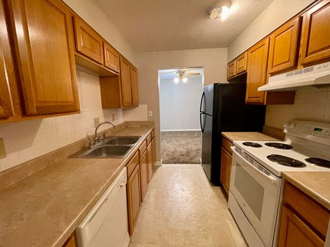 a kitchen with white appliances and wooden cabinets