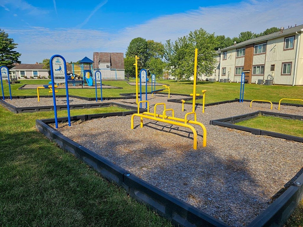 a playground at a park in front of an apartment building