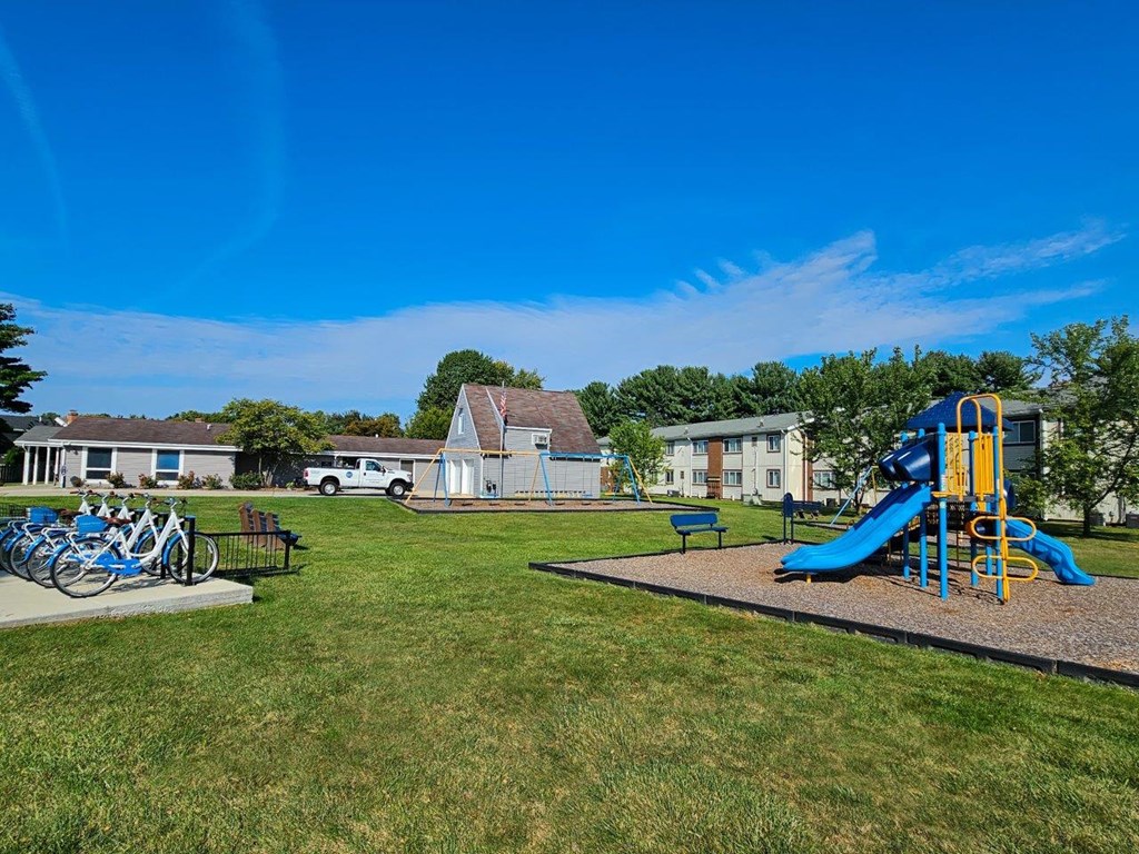 a playground with a slide and bikes in a park