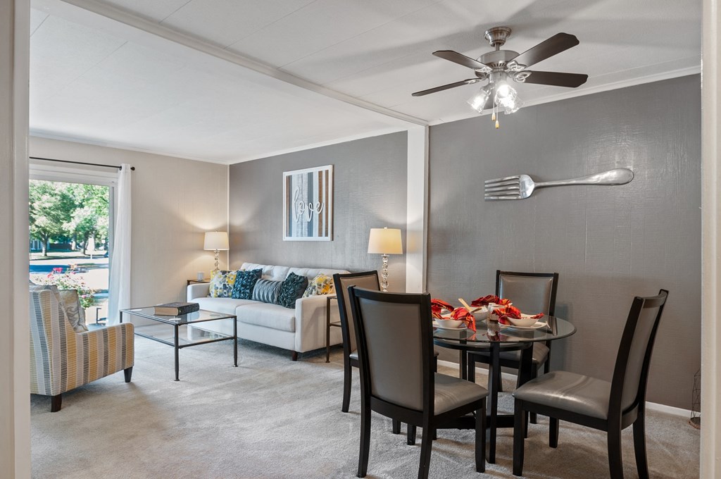 a living room with a dining room table and a ceiling fan