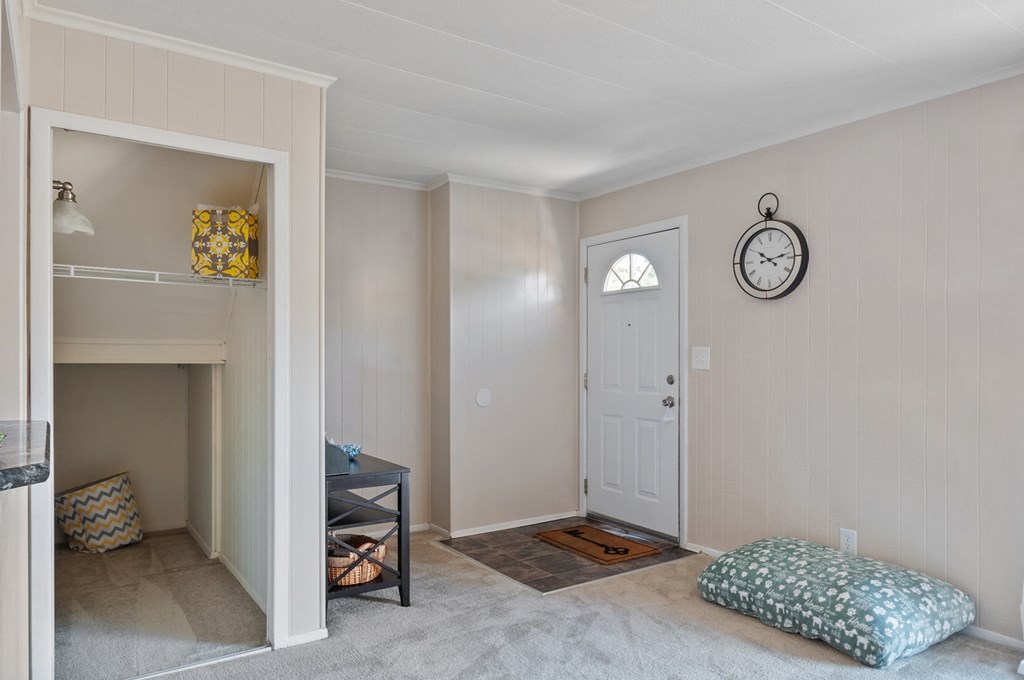 a living room with a white door and a clock on the wall