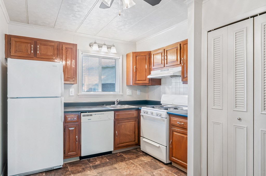 a kitchen with white appliances and wooden cabinets