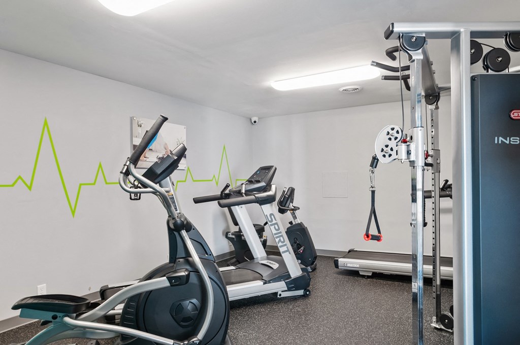 a gym with treadmills and weights and a graph on the wall