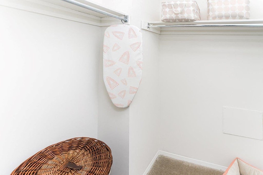 a white closet with a paddle board on the wall