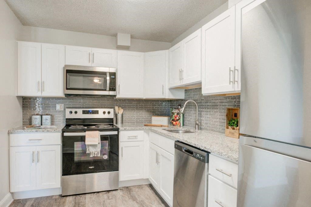 a kitchen with stainless steel appliances and white cabinets