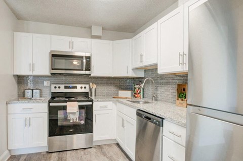 a kitchen with stainless steel appliances and white cabinets