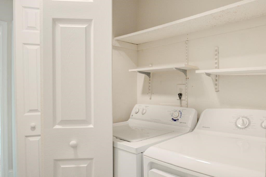 a white laundry room with two washes and a dryer