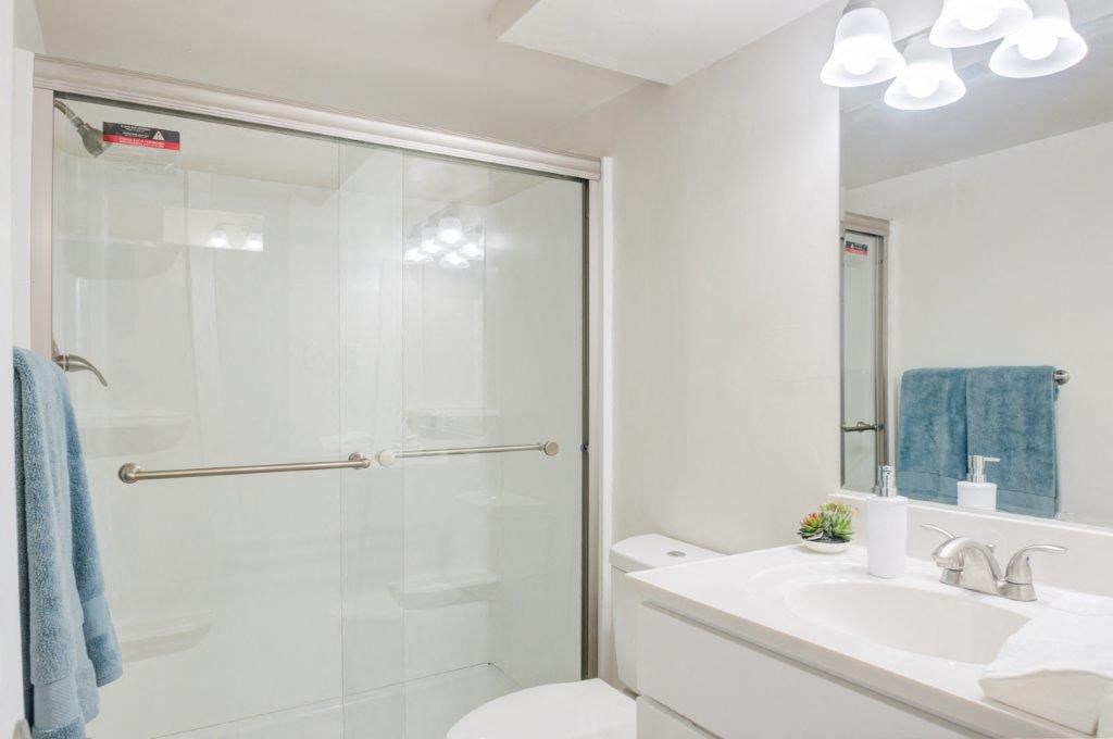 a bathroom with a shower and a sink and a toilet