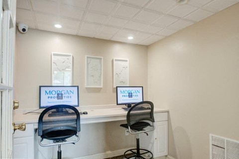 two computer desks in a room with two chairs