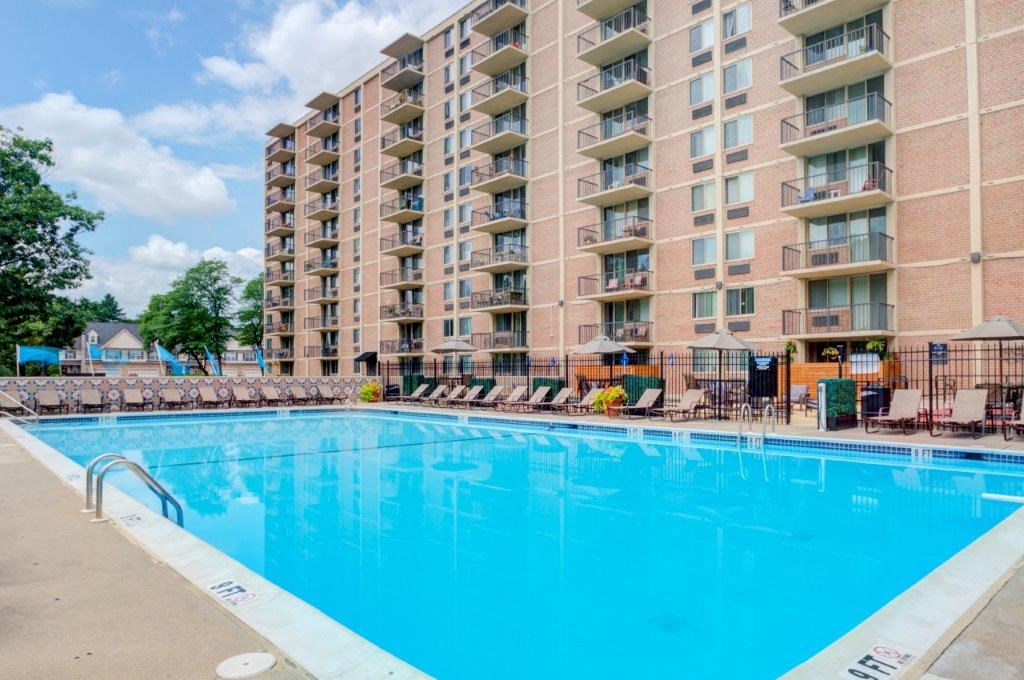 a large blue pool in front of an apartment building