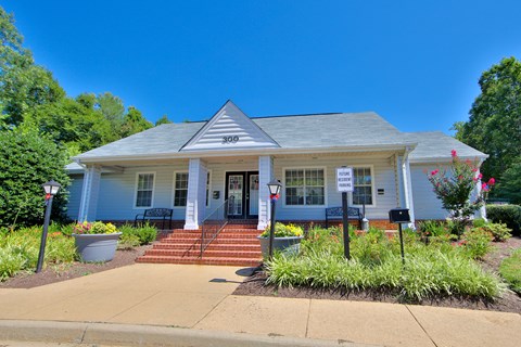 the front of a white house with a porch and landscaping