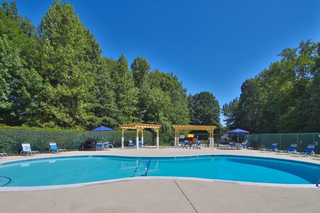 a swimming pool with trees in the background and a blue sky