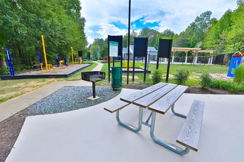 a picnic table and a bench in a park
