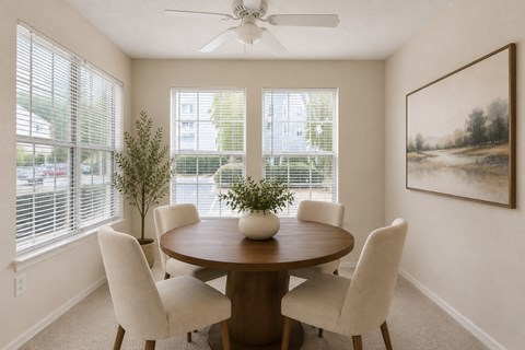 A dining room with a round table and chairs.