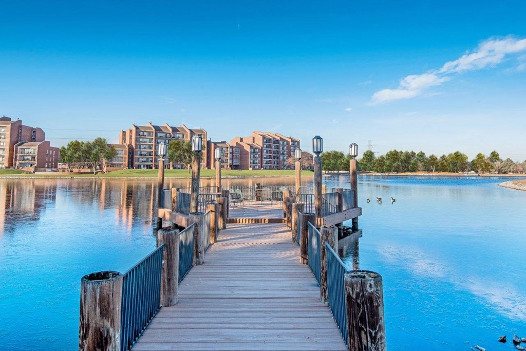 a dock on the water with buildings in the background