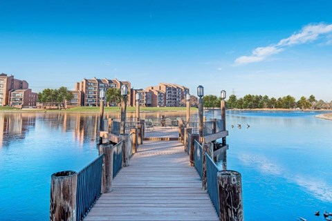 a dock on the water with buildings in the background