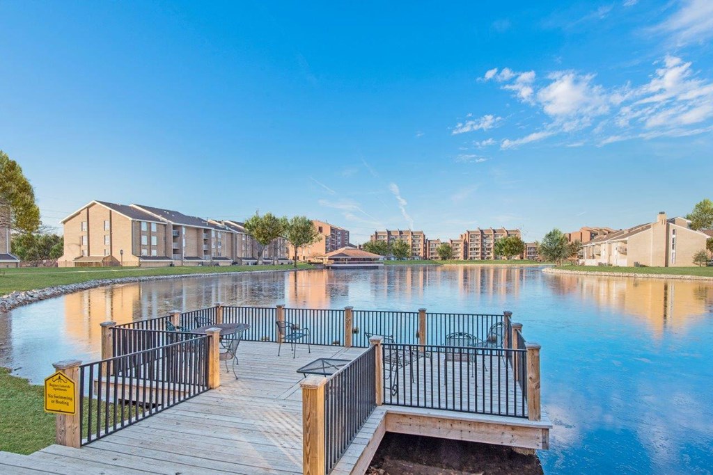 a dock on a lake with buildings in the background