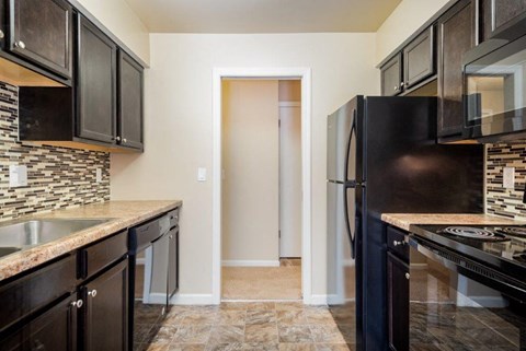 a kitchen with black appliances and a black refrigerator