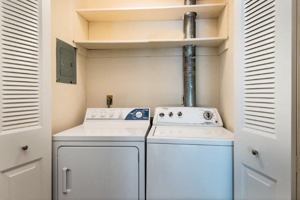 a white washer and dryer in a laundry room with a exhaust fan