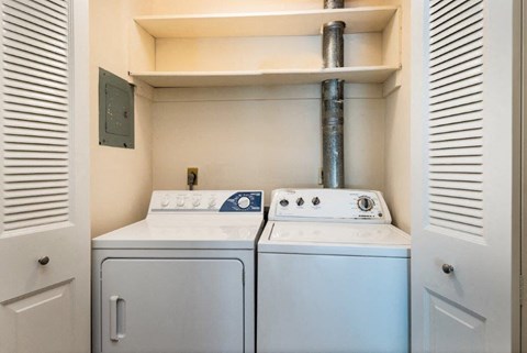 a white washer and dryer in a laundry room with a exhaust fan