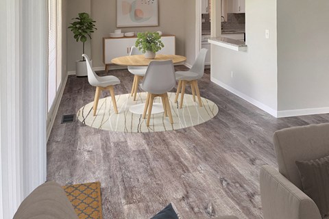 a living room with a wooden floor and a table and chairs